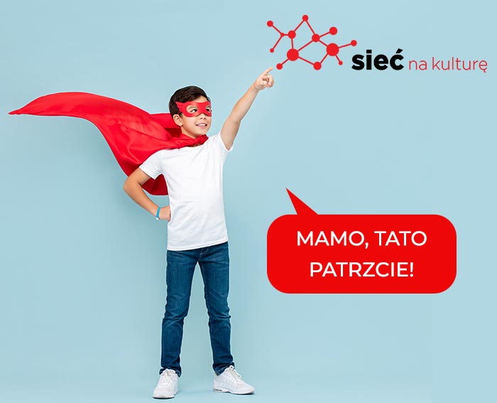 Chłopiec w pelerynie Superman wskazuje na logo Sieć na kulturę i mówi Mamo, Tato Patrzcie